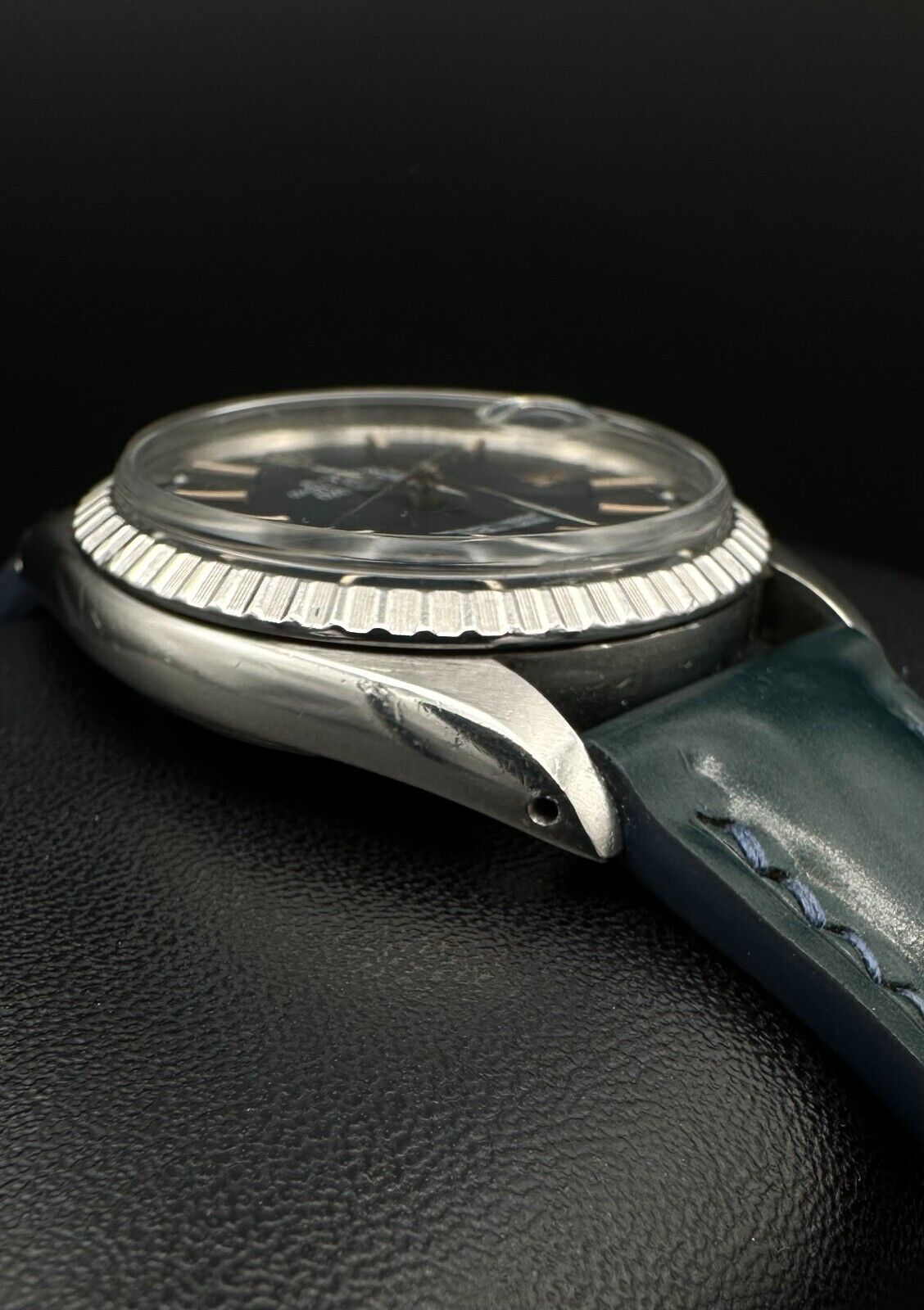 Rolex Datejust 36mm automatic watch, model 1603, featuring a blue dial and distinctive engine-turned bezel, from 1975. This vintage timepiece offers a blend of timeless design and enduring craftsmanship, ideal for collectors and enthusiasts of classic Rolex watches. Available from The Watch Trader in Madison, Connecticut.