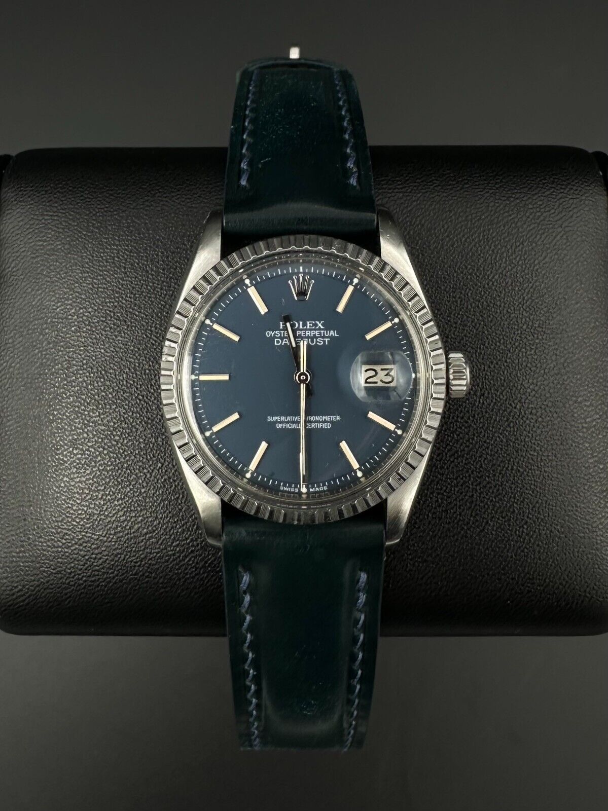 Rolex Datejust 36mm automatic watch, model 1603, featuring a blue dial and distinctive engine-turned bezel, from 1975. This vintage timepiece offers a blend of timeless design and enduring craftsmanship, ideal for collectors and enthusiasts of classic Rolex watches. Available from The Watch Trader in Madison, Connecticut.
