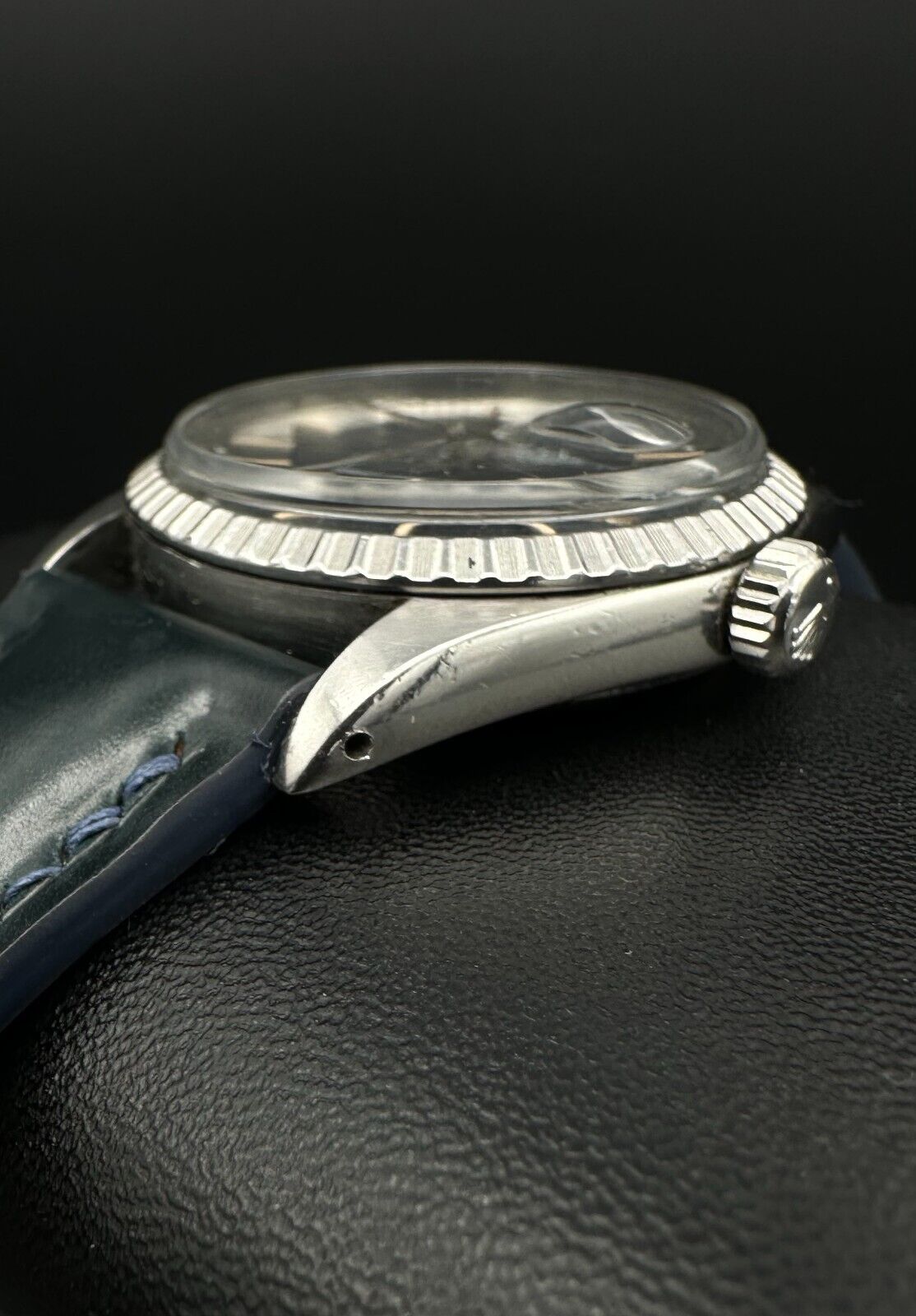 Rolex Datejust 36mm automatic watch, model 1603, featuring a blue dial and distinctive engine-turned bezel, from 1975. This vintage timepiece offers a blend of timeless design and enduring craftsmanship, ideal for collectors and enthusiasts of classic Rolex watches. Available from The Watch Trader in Madison, Connecticut.
